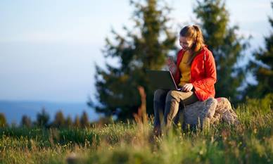 Woman on laptop in a field