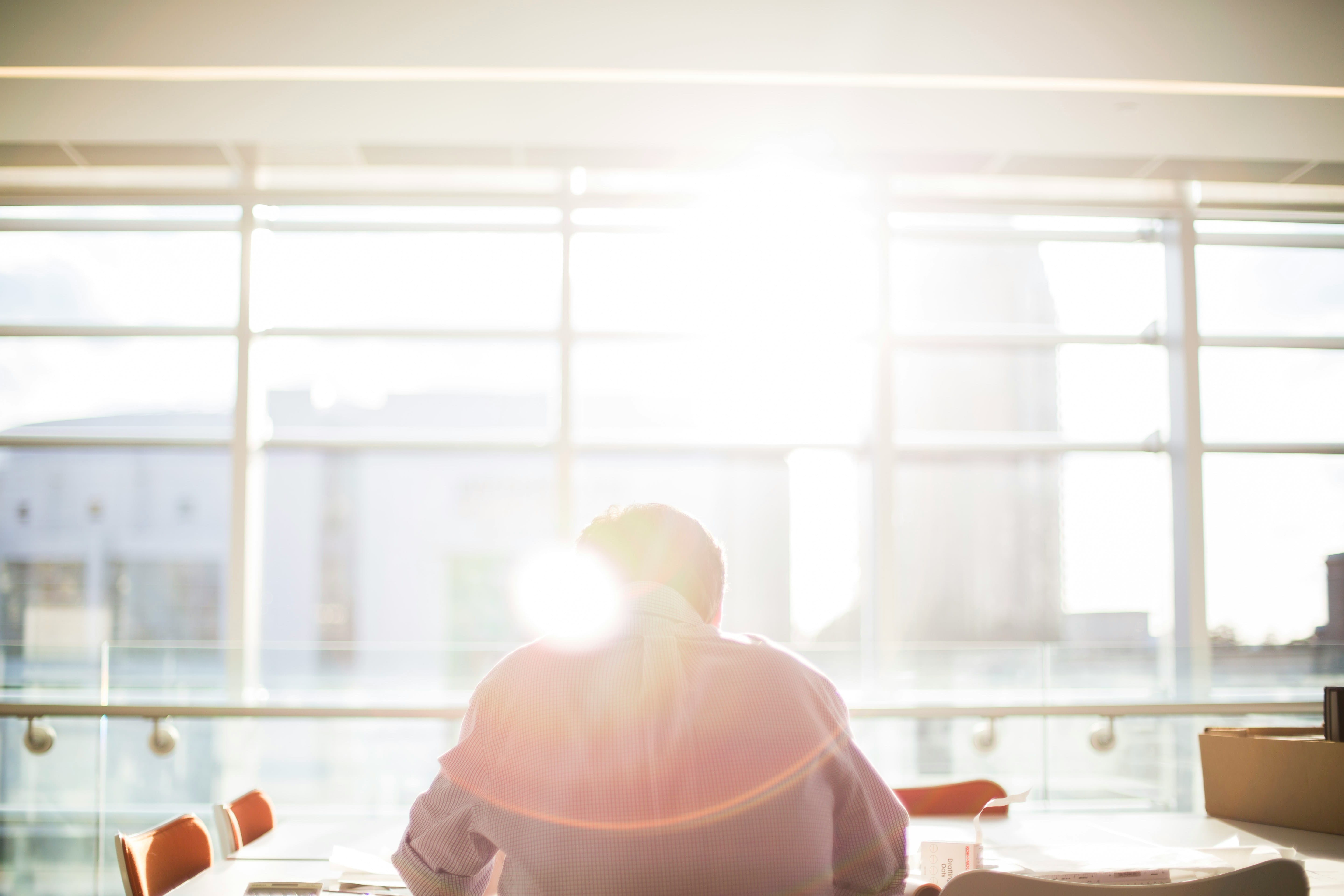 Man sat at desk looking out of window
