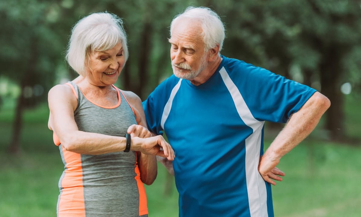 Elderly couple looking at activity tracking device