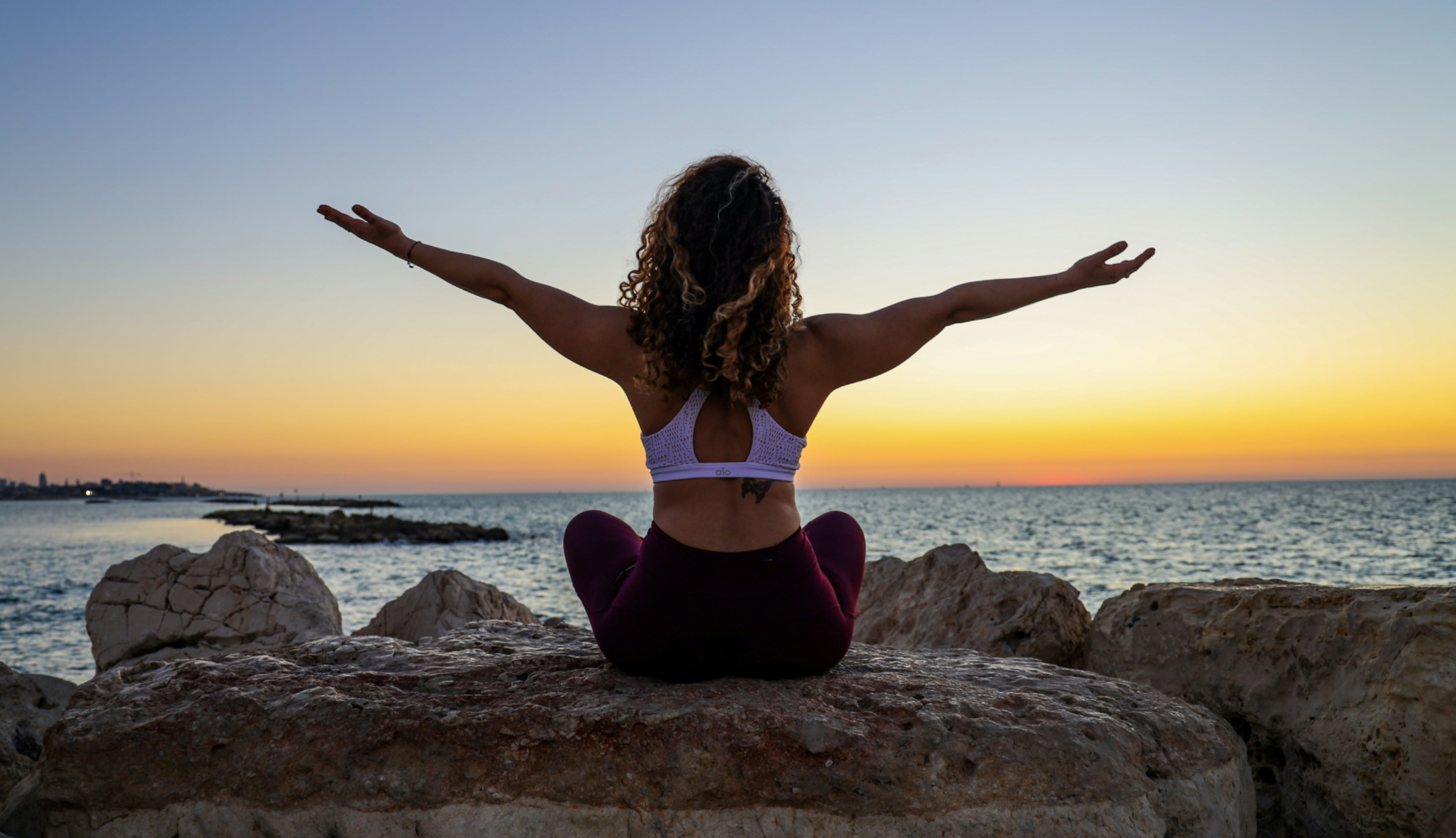 woman-meditating-sunset-beach