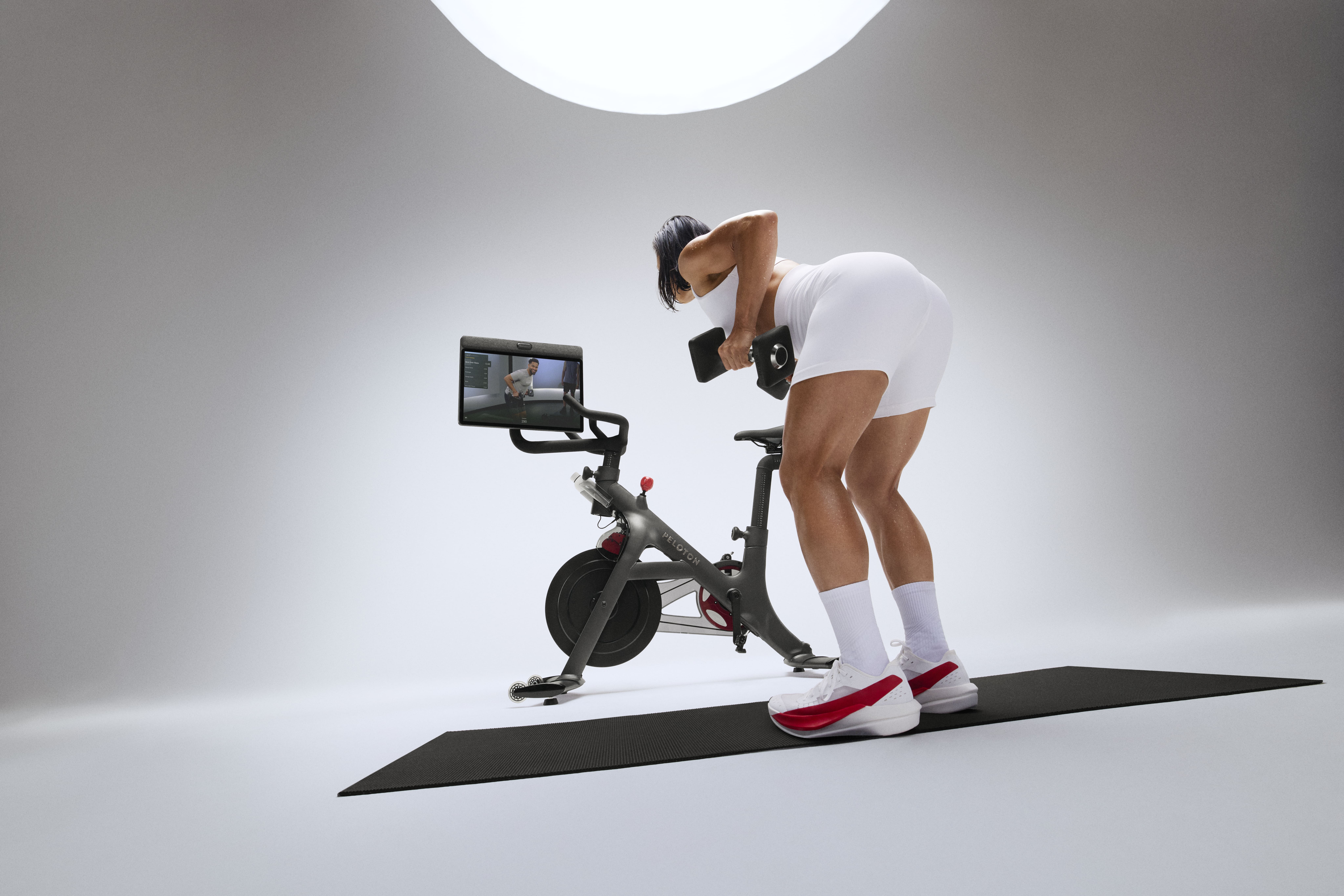 Woman exercising on mat with Peloton Swivel Screen