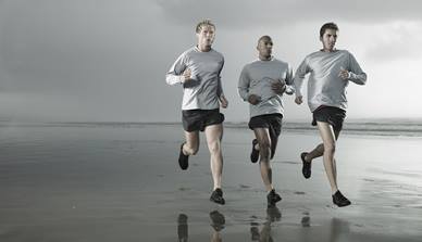 Men running along beach