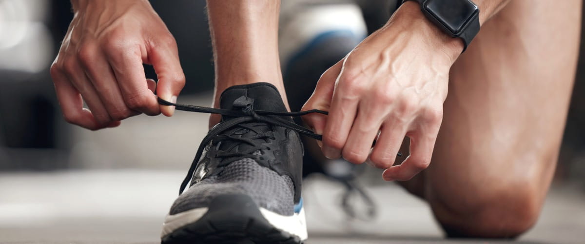 person-tying-up-running-shoes