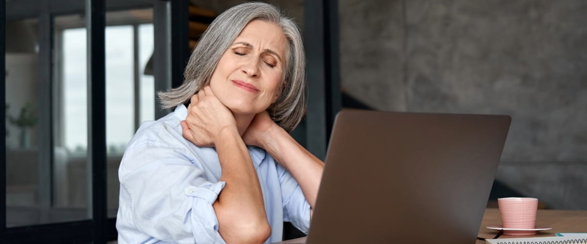 woman-sat-at-desk-with-neck-pain